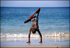 Un joven afectado por la poliomielitis se divierte en la playa de Benguela, Angola